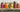Five jars of various fermented foods sitting on a wooden counter.