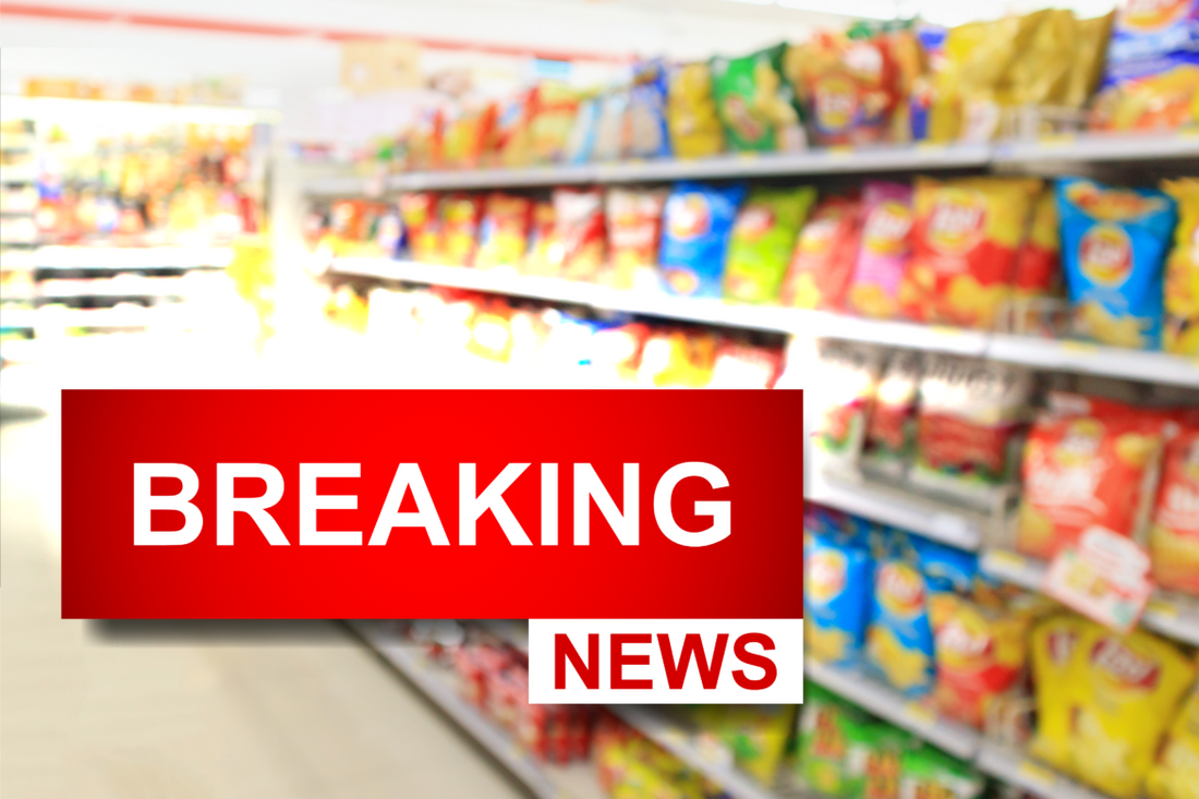 View of the chip aisle of a grocery store with a breaking news icon overlayed over top it.