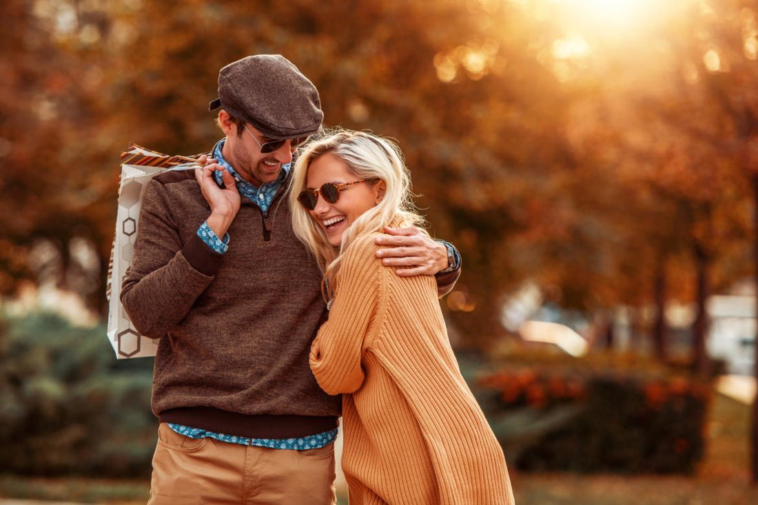 Young couple smiling and hugging while on an autumn walk.