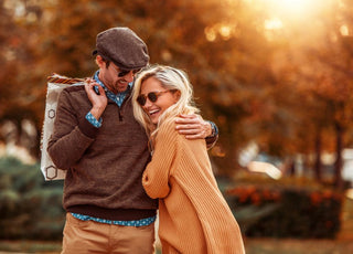 Young couple smiling and hugging while on an autumn walk.