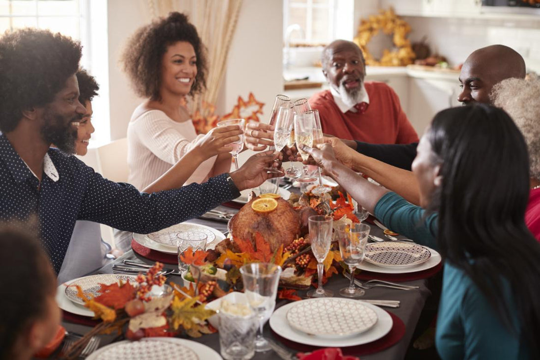 Family sitting around the dinner table clinking glasses.
