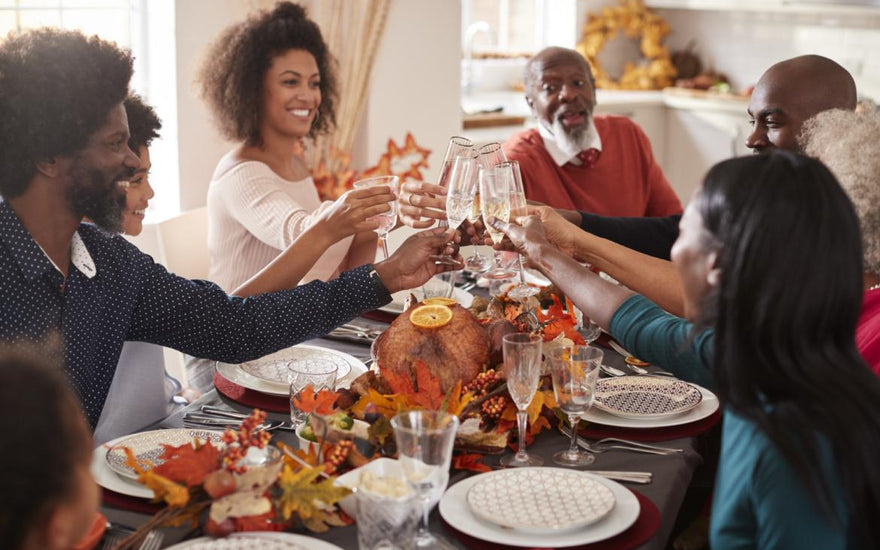 Family sitting around the dinner table clinking glasses.