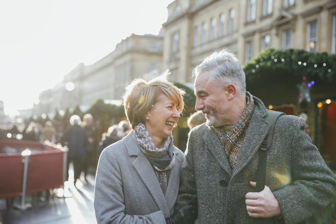 Older couple smiling at each other while at an outdoor holiday event.