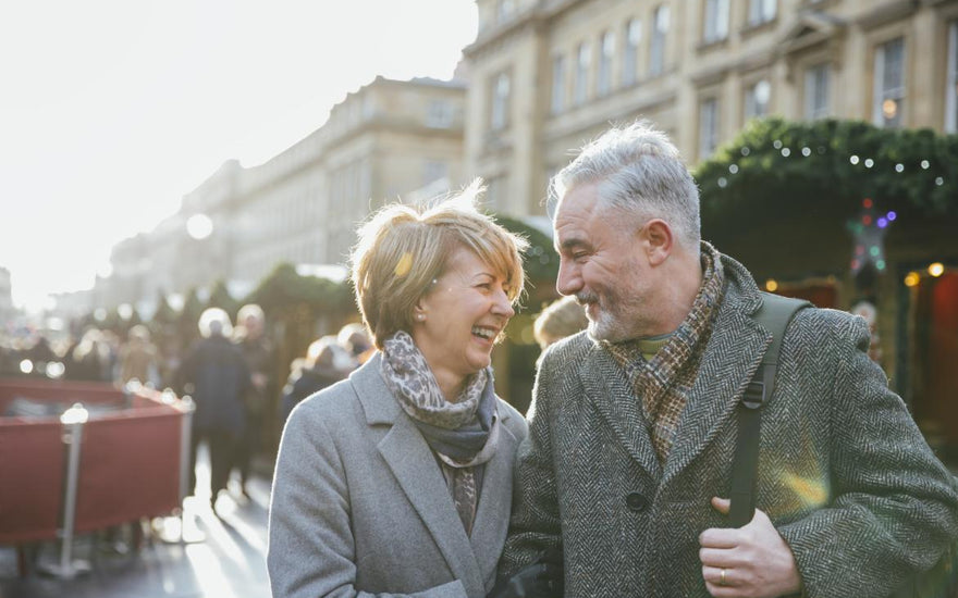 Older couple smiling at each other while at an outdoor holiday event.