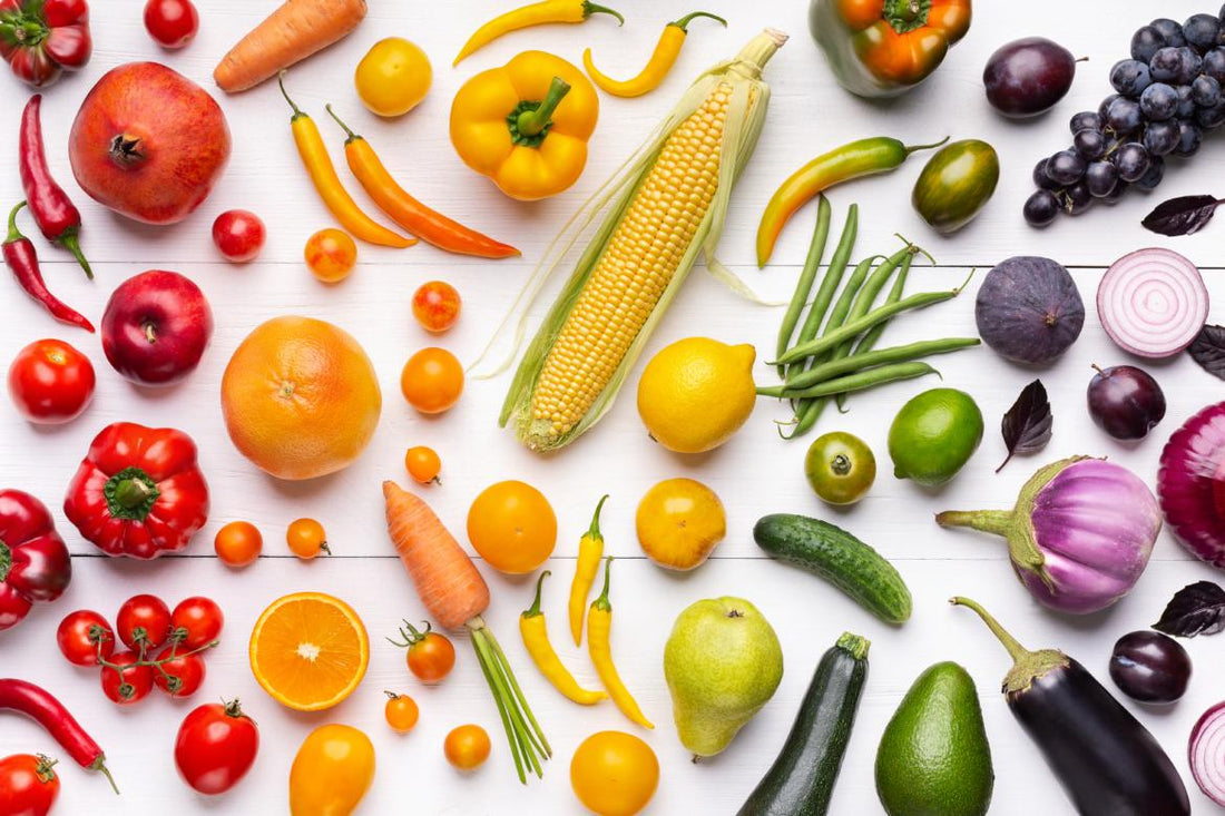 A table full of fresh fruits and vegetables arranged according to color.