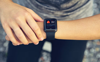 Person looking at their smart watch partway through a workout.