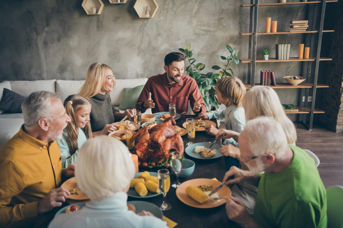 Multi-generational family sitting around a table enjoying a holiday meal.