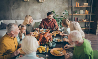 Multi-generational family sitting around a table enjoying a holiday meal.