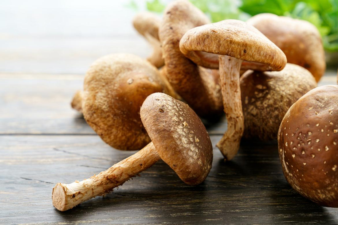 A small pile of mushrooms laying on a wooden tabletop. 
