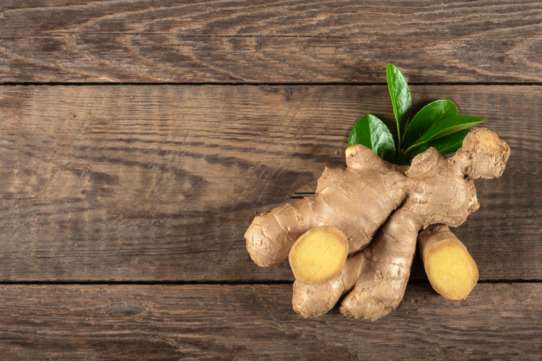 A fresh clump of ginger sitting on a dark wood tabletop.