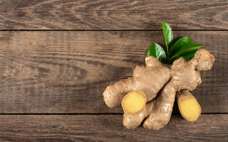 A fresh clump of ginger sitting on a dark wood tabletop.