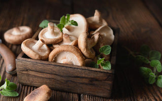 Wooden crate filled with fresh mushrooms.