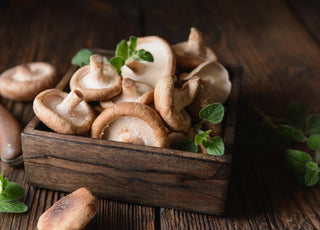 Wooden crate filled with fresh mushrooms.