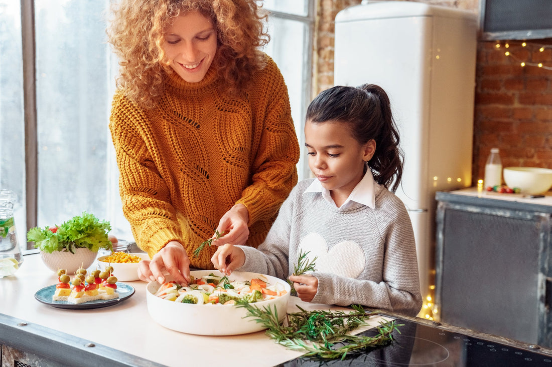 Happy woman and a young girl making healthy vegan food for a family gathering. 