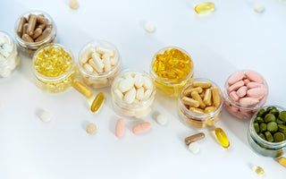 Ten small, clear plastic containers each holding a different type of vitamin or supplement.