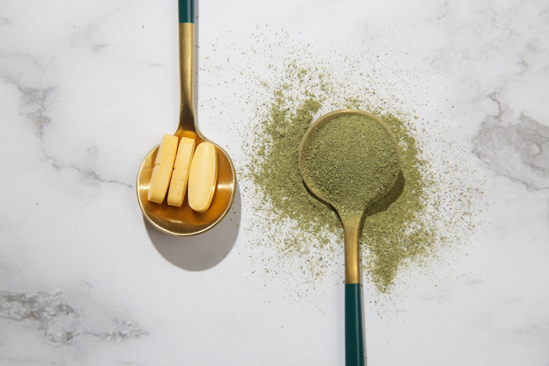 Green powder and pills in spoons.