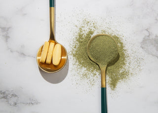 Green powder and pills in spoons.