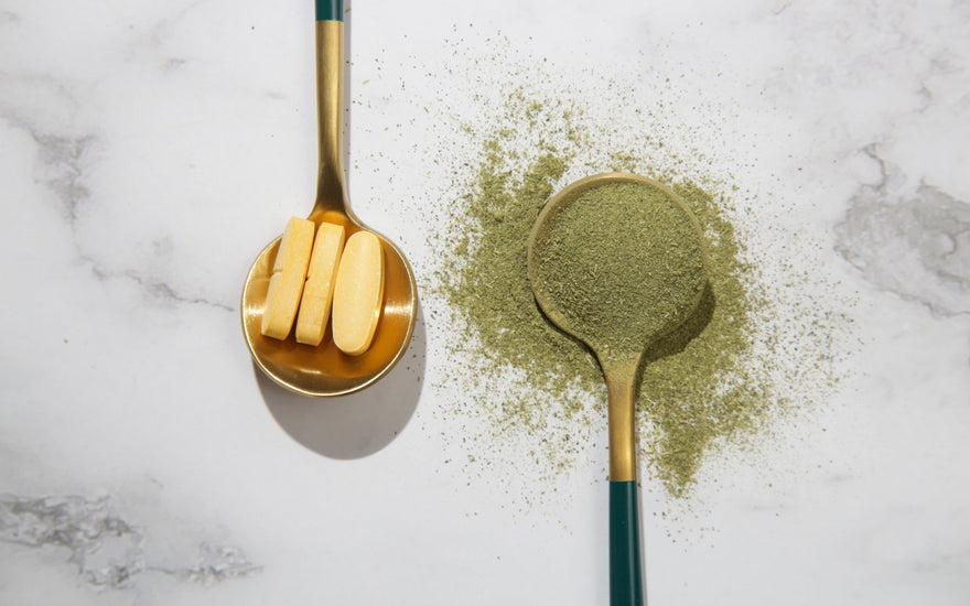 Green powder and pills in spoons.