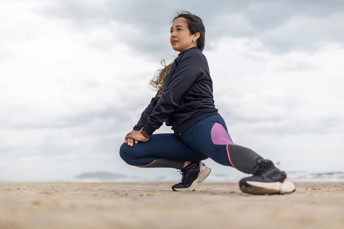 Woman stretching her legs on the beach. 
