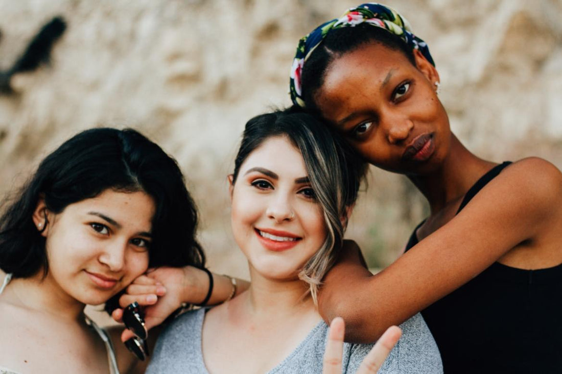Three diverse women posing together.